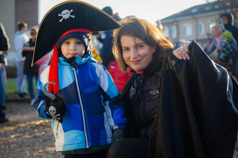 A mother and son dressed as pirates enjoying a Halloween event outdoors.
