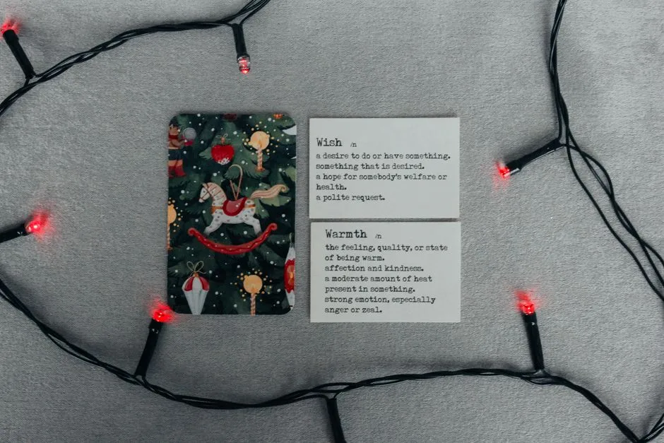 A holiday card and string lights with inspiring definitions set on a festive background.