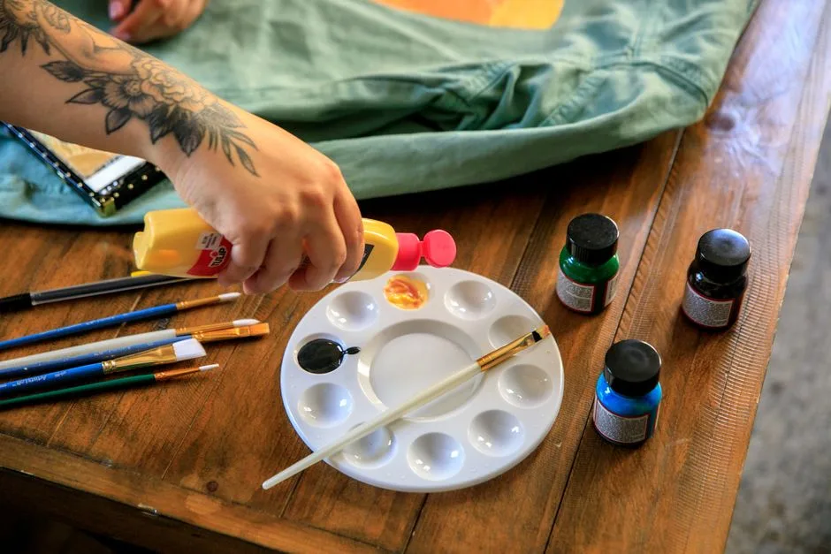 A creative setup with paints and brushes on a wooden table, ready for a painting session.