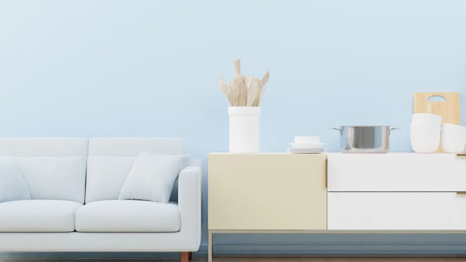 Stylish minimalist living room with a cozy sofa and elegant kitchen decor.