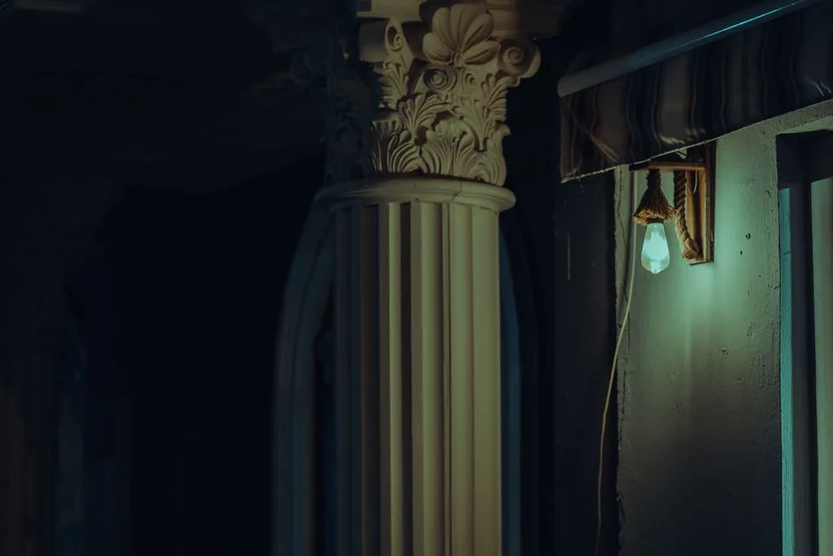 A classic architectural column highlighted by soft nocturnal lighting, showcasing intricate details.