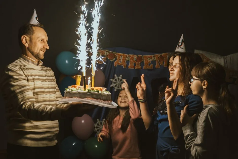 A family celebrating a birthday with a sparkling cake and joyful moments indoors.