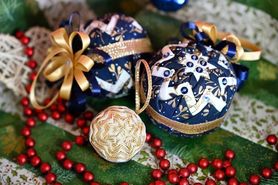 Close-up of handmade fabric Christmas ornaments with red beads on a festive background.