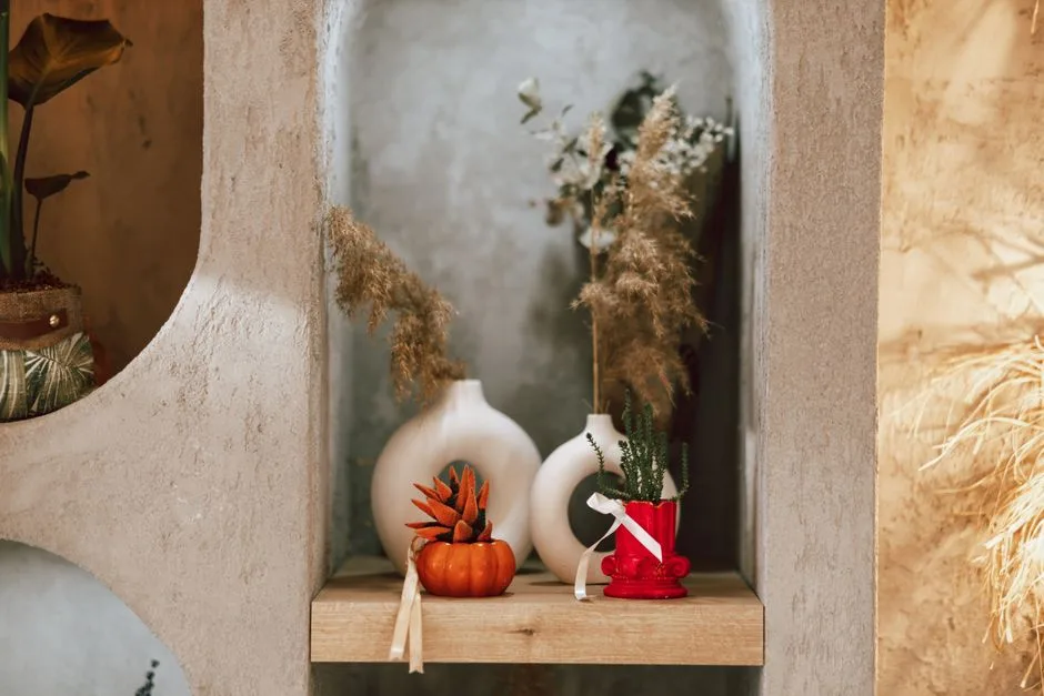 Stylish interior shelf showcasing autumn-themed floral decorations and vases.