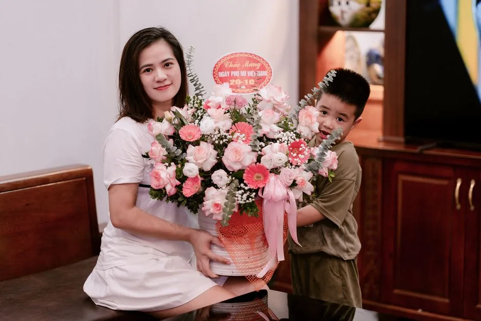 Woman and child indoors with a large bouquet celebrating Vietnamese Women's Day.