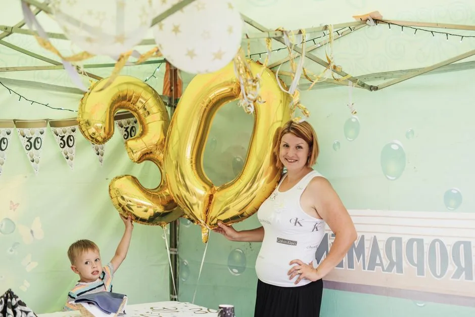 A cheerful 30th birthday party featuring gold balloons and decorations.