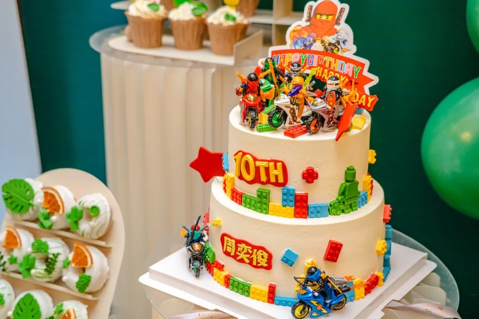 Vibrant birthday cake with toy figures and blocks for a 10th celebration. Perfect for children's parties.