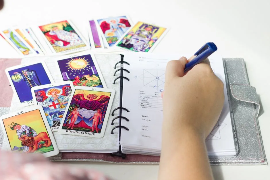 Colorful tarot cards and journal writing, signifying a tarot card reading session.
