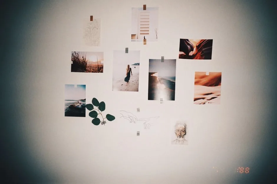 A stylish wall collage featuring photos and art prints taped on a light-colored wall, perfect for modern home decor.