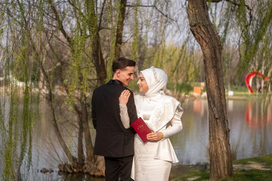 A joyful couple embracing by a lake in a serene outdoor wedding setting. Springtime romance captured beautifully.