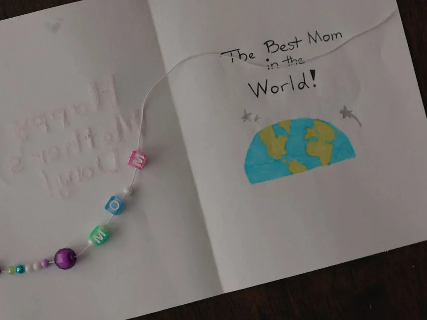 Handmade Mother's Day card featuring beaded bracelet and heartfelt message.