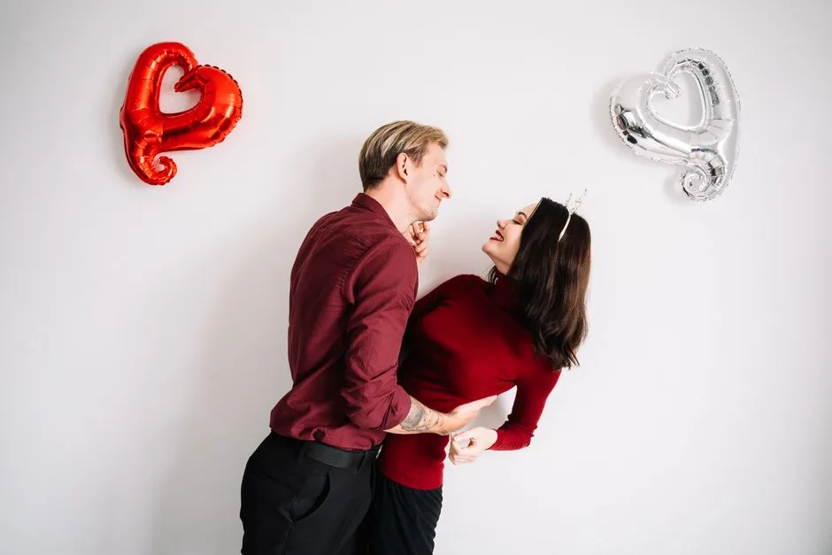 A couple joyfully embracing with heart-shaped balloons, symbolizing romance and love.