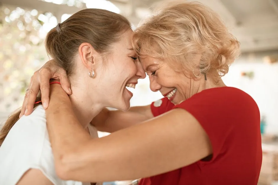 A heartwarming moment of two women smiling and embracing affectionately indoors.