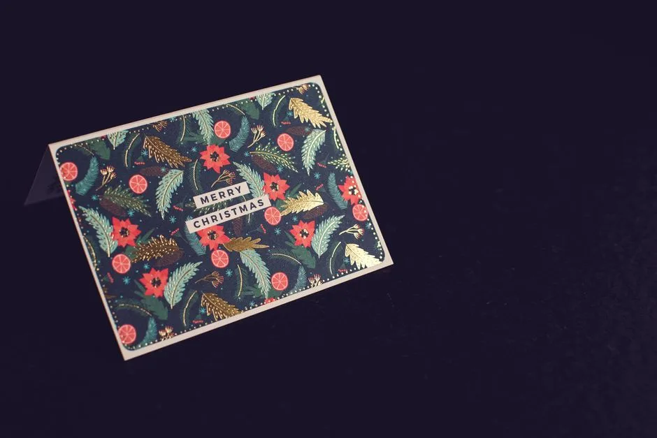 Elegant 'Merry Christmas' card with festive botanical design on a dark background.