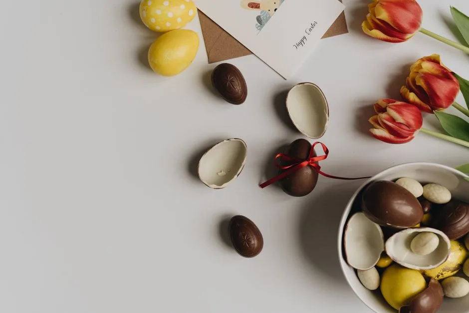 A festive Easter flat lay featuring chocolate eggs, tulips, and a greeting card.