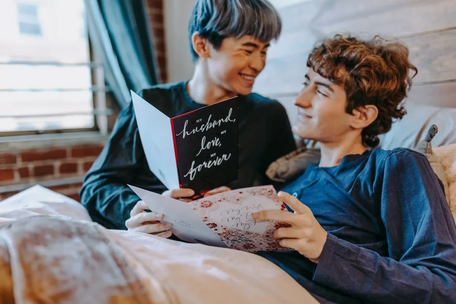 A couple enjoying a heartfelt moment reading romantic cards in a cozy bedroom.