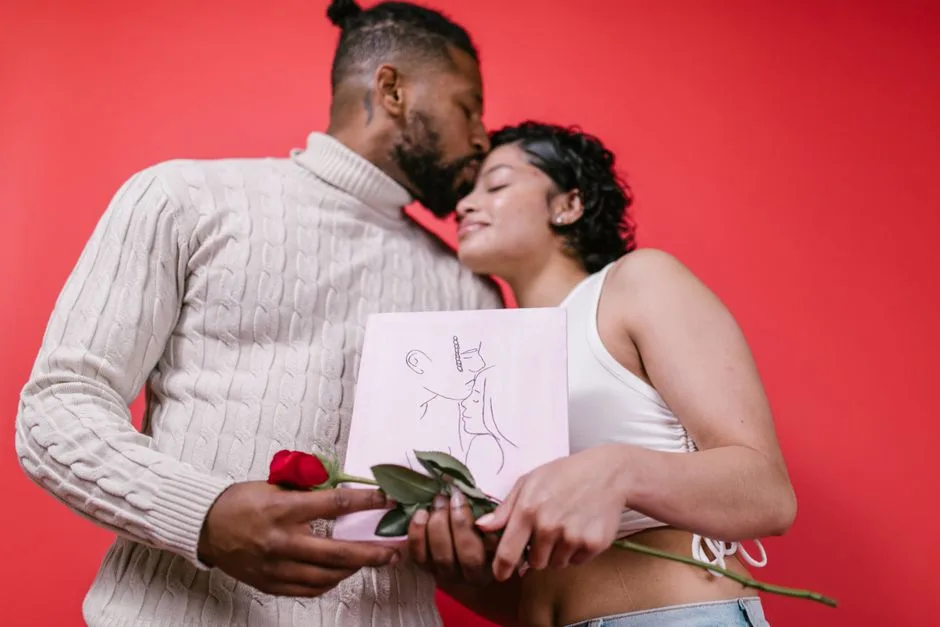 A loving couple embraces with a rose and gift on Valentine's Day.
