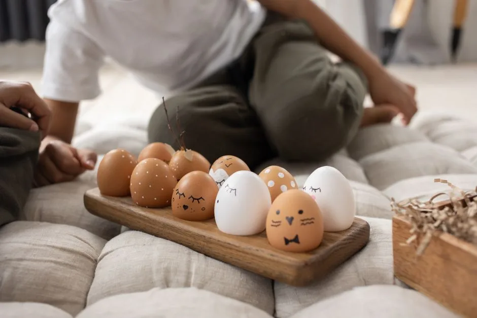 Creative Easter eggs with painted faces and designs on a wooden board, indoor shot.