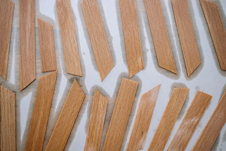 Top view of wooden craft sticks laid out in a pattern on a white surface, highlighting woodworking details.