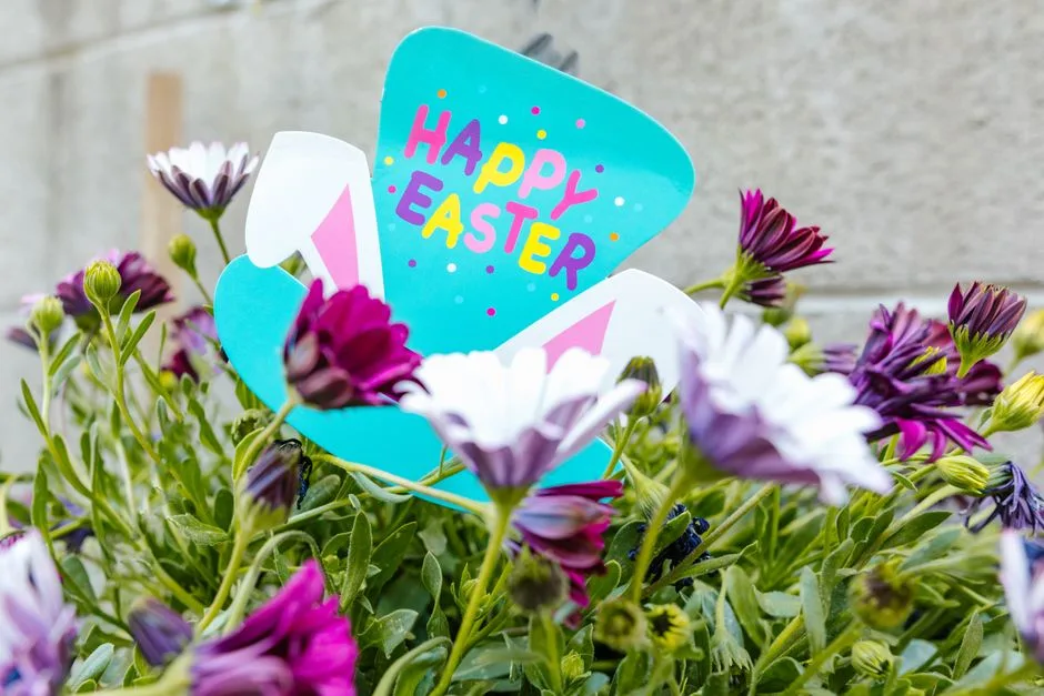 Colorful Easter greeting card surrounded by blooming flowers. Perfect for spring celebrations.