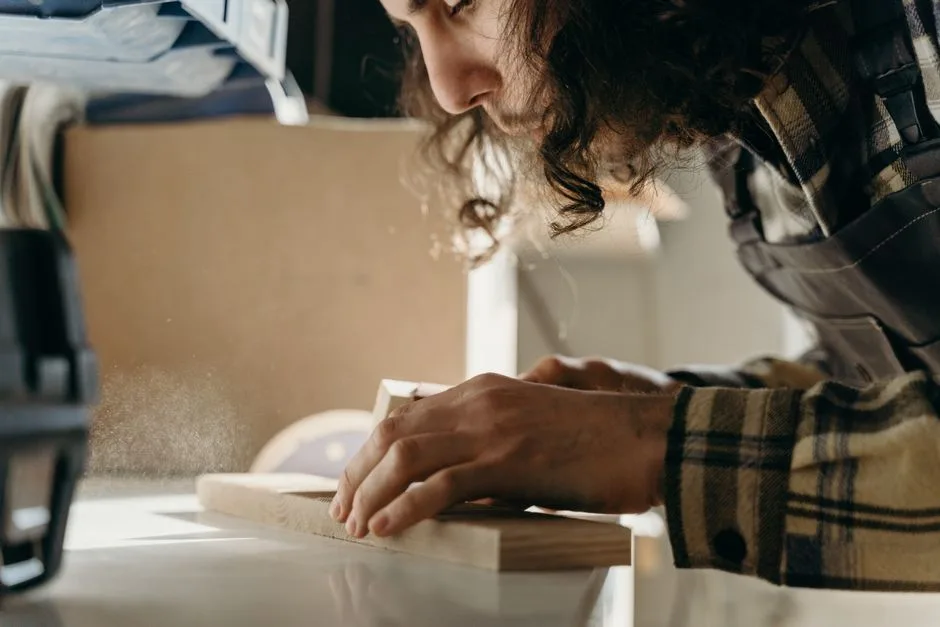 A dedicated craftsman skillfully sanding a wooden board in a cozy workshop setting.