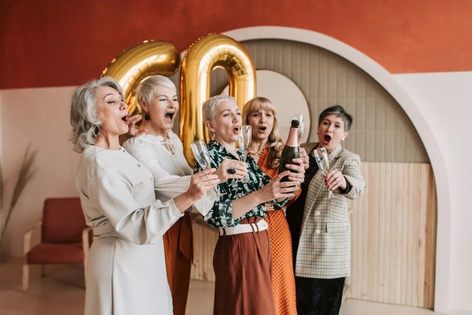 Joyful senior women celebrating a 60th birthday with champagne.