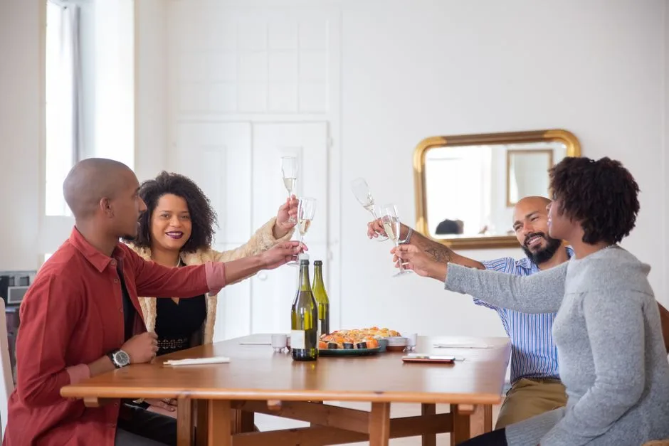 A cheerful group of friends enjoying a toast with wine at home, celebrating together.