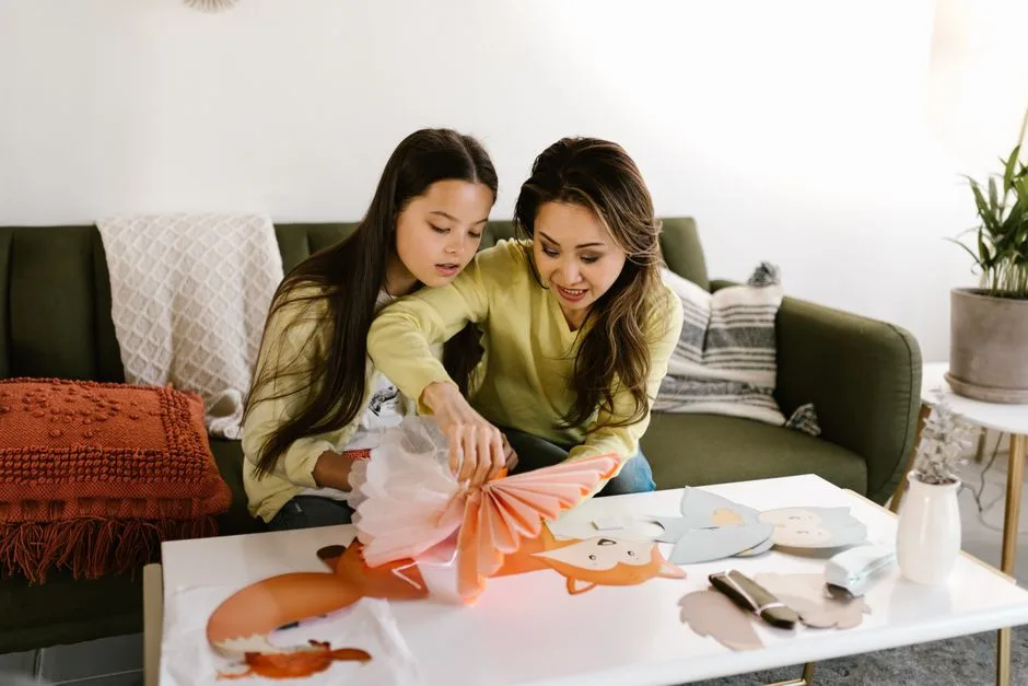 A mother and daughter enjoy quality time creating crafts together in a cozy living room.