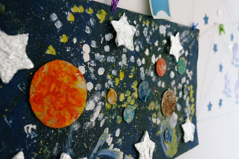 Colorful craft of painted planets and stars for preschool space education display.