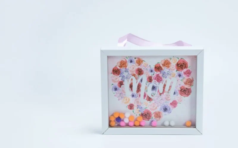 Heart-shaped floral design with 'Mom' text in a frame, perfect for Mother's Day gift.