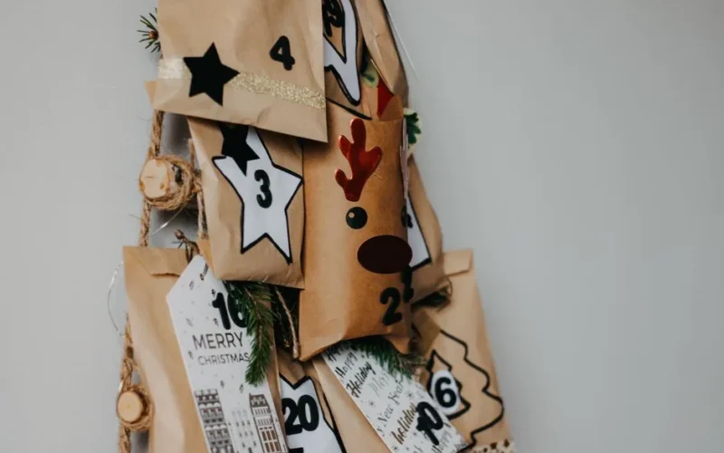 Handcrafted advent calendar with decorated paper bags and festive numbers for Christmas countdown.