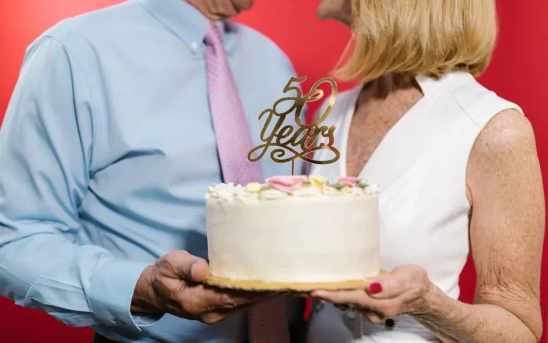 A couple celebrating their 50th anniversary with a decorative cake, symbolizing a lasting bond.