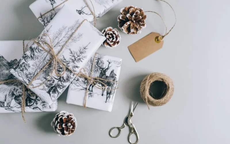 Beautifully wrapped Christmas presents with pine cones and twine in a minimalist style. Perfect for holiday inspiration.