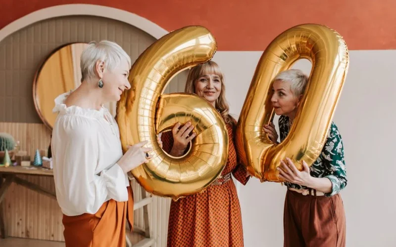 Joyous gathering with women celebrating a 60th birthday indoors.