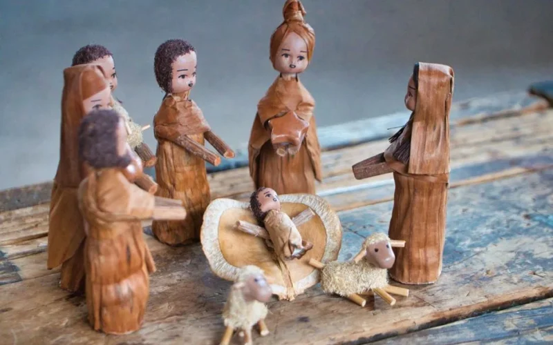 Charming handmade nativity scene depicting Baby Jesus, Mary, and others in a traditional wooden style.