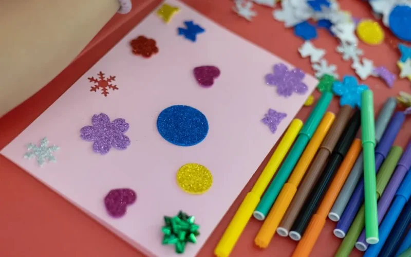 A vibrant handmade card decorated with glitter and stickers, perfect for creative projects.