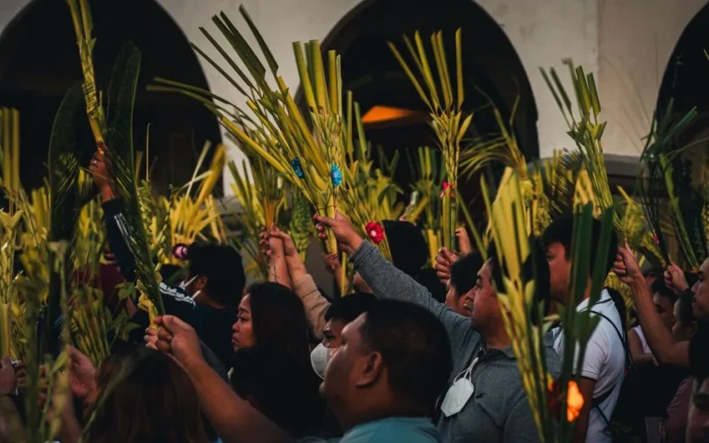 Vibrant Palm Sunday gathering in Baguio City with people holding palm fronds in a cultural celebration.