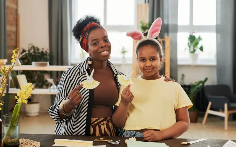 Mother and daughter crafting together, creating fun paper bunnies in a cozy indoor setting.