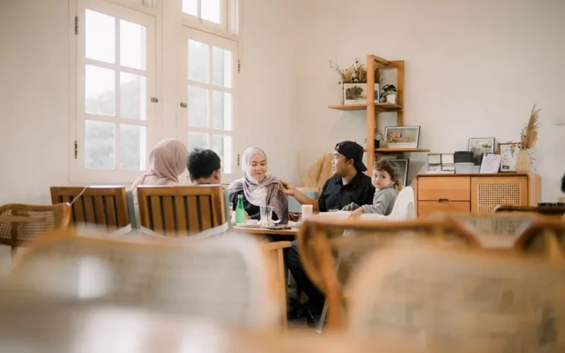A joyful family having a meal inside a cozy room, sharing smiles and quality time together.