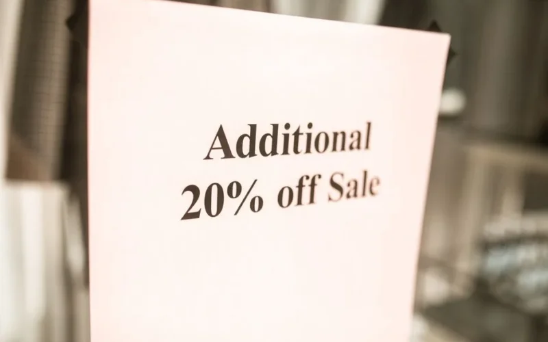 Close-up of a sale sign offering an additional 20% discount in a store window.