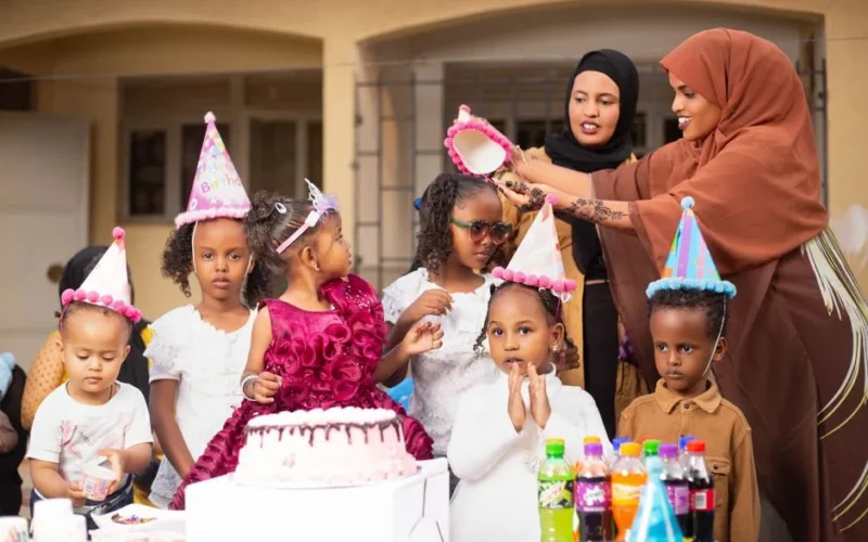 Happy children at a colorful outdoor birthday party enjoying cake and fun.