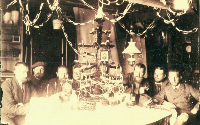 Christmas 1882 in the common living- und workroom of the station seen from the NE corner of the room Dr. Schrader, Dr. Vogel, Dr. v. d. Steinen, Mech. Zschau, Ing. Mosthaff, Dr. Will, Dr. Clauß decorated table with artificial Christmas tree with presents from home