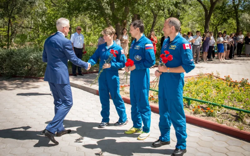 At their Cosmonaut Hotel crew quarters in Baikonur, Kazakhstan, Expedition 56 backup crew members Anne McClain of NASA, Oleg Kononenko of Roscosmos and David Saint-Jacques of the Canadian Space Agency receive a gift of flowers and congratulations from local officials May 21 as part of their pre-launch activities. They are the backups to the prime crew, Serena Aunon-Chancellor of NASA, Sergey Prokopyev of Roscosmos and Alexander Gerst of the European Space Agency, who will launch June 6 on the Soyuz MS-09 spacecraft from Baikonur for a six-month mission on the International Space Station.