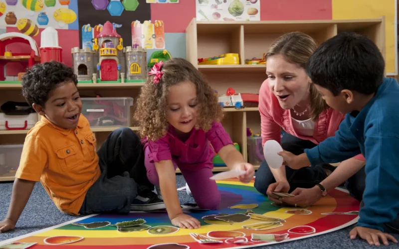 Preschool students and teacher matching food cutouts with the colors of the rainbow in the classroom. For more nutrition education resources, visit the Team Nutrition website at: www.TeamNutrition.usda.gov. All photos are property of USDA with unlimited rights to the use and redistribution of the images.