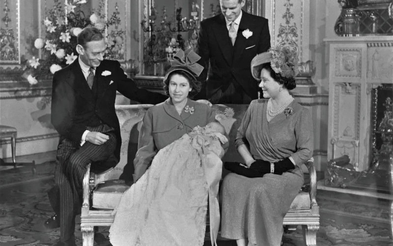 Family portrait of King George VI of the United Kingdom (at left), with Queen Elizabeth (at right), their daughter, Princess Elizabeth (later Queen Elizabeth II; center) and son in law Phillip, Duke of Edinburgh (behind), after the christening ceremony of Charles (later Charles III). (photographed in his mother's arms).