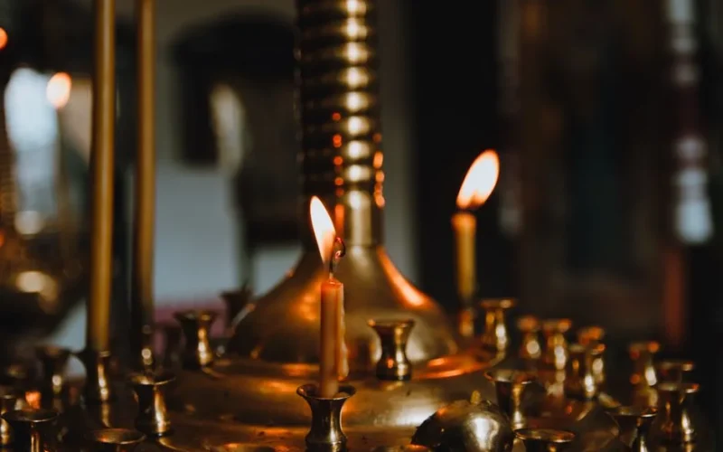 Close-up of flickering candles illuminating a traditional Ukrainian church interior.