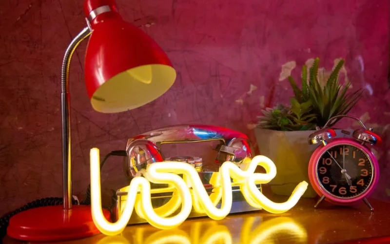 Bright neon love sign with retro decor, perfect for romantic vibes.