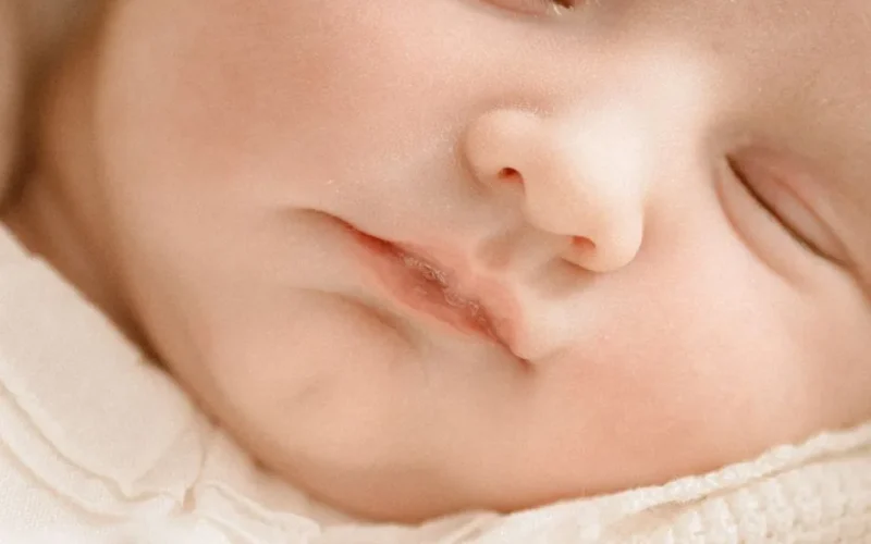Close-up of a peacefully sleeping baby with eyes closed, showcasing soft features and serene expression.