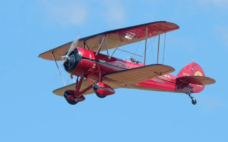 Red NuWaco T-10 Taperwing (based on the Waco ATO) flying in blue sky