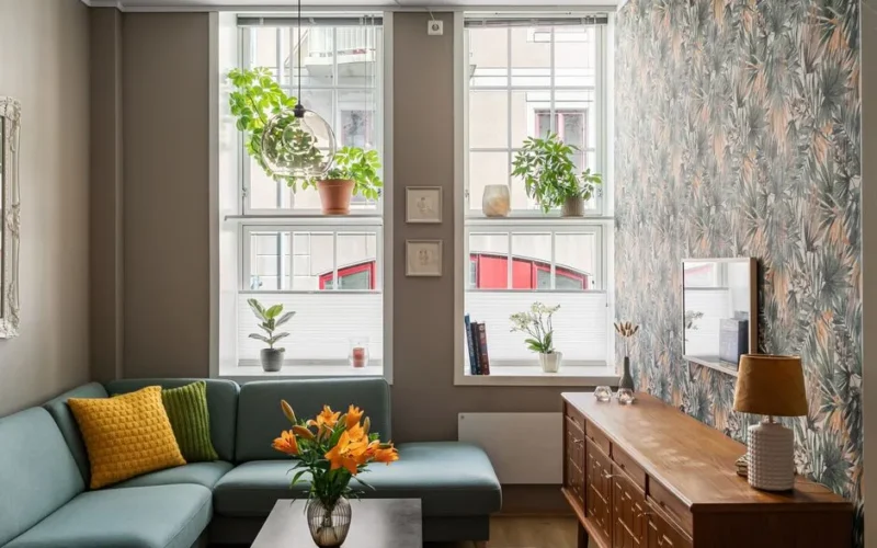 Stylish living room with abundant natural light, plants, and cozy decor.